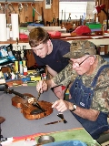 Fred Beavers works on a fiddle